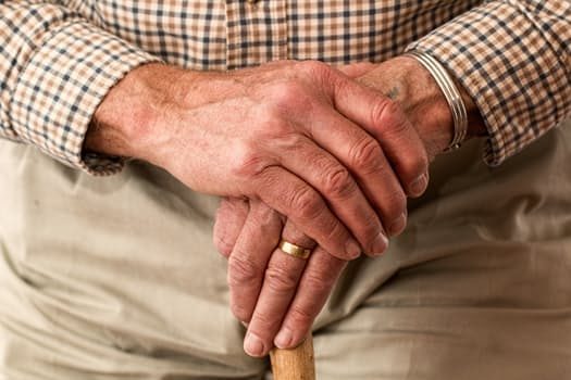 Image of elderly hands on cane