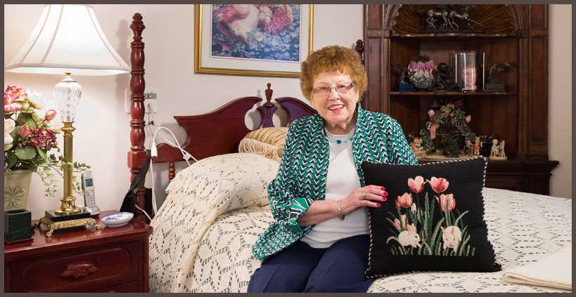 Photo of woman sitting on bed at Carriage House Inn