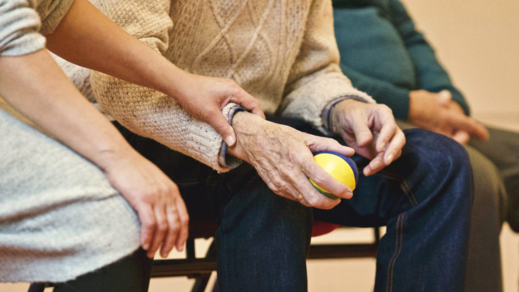 Elderly man holding stress ball