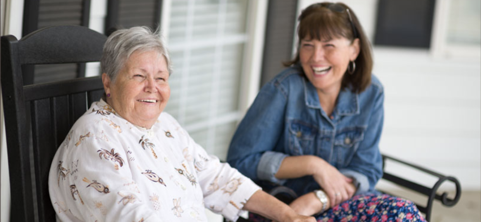 Photo of two women laughing on the porch of Antebellum Grove